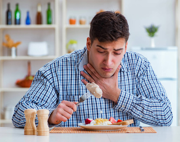 Mann isst zu Hause geschmackloses Essen zum Mittagessen - Foto, Bild