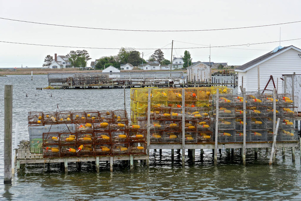 Huizen en krabbetjes aan de kust van Tanger Island, Virginia, in de Chesapeake Bay. Sinds 1850 is de landmassa van de eilanden met 67 procent verminderd; de resterende landmassa zal naar verwachting in 2068 verloren gaan.. - Foto, afbeelding