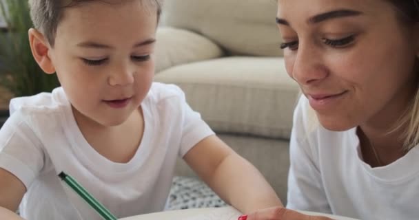 Mother with son drawing on paper at home - Footage, Video