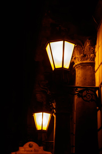 Farol de calle vintage iluminado en la pared de una casa por la noche - Foto, Imagen