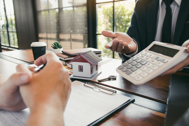 Agents are calculating the loan payment rate or the amount of insurance premiums for customers coming to contact the purchase of a new home at the office. - Photo, Image