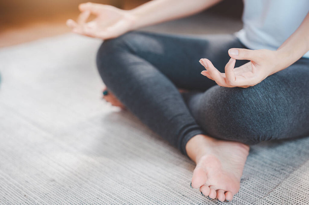 Colpo raccolto di donna asiatica sportiva attraente praticare la meditazione yoga a casa  - Foto, immagini