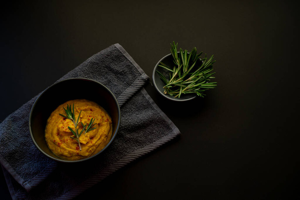 Wegetariańska zupa z puree z masłem i marchewką na ciemnej powierzchni. Rosemary i pory w menu dla zdrowego odżywiania. - Zdjęcie, obraz