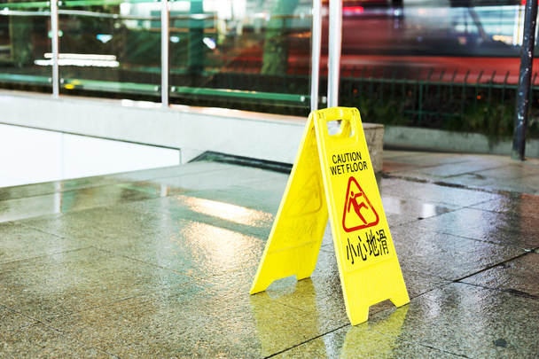 πρόσφατα mopped διάδρομο με ένα σημάδι προσοχή στα αγγλικά. - Φωτογραφία, εικόνα