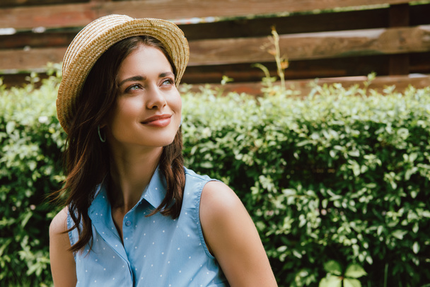 happy young woman in straw hat looking away outside - Fotoğraf, Görsel