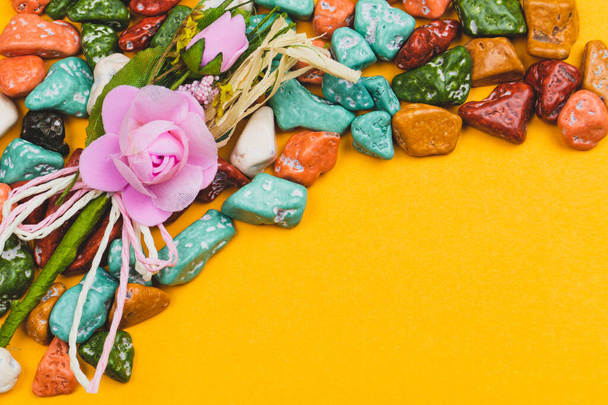 Festive decoration. candy pebbles. sweets in the form of colored stones on a yellow background. copy space - Fotografie, Obrázek