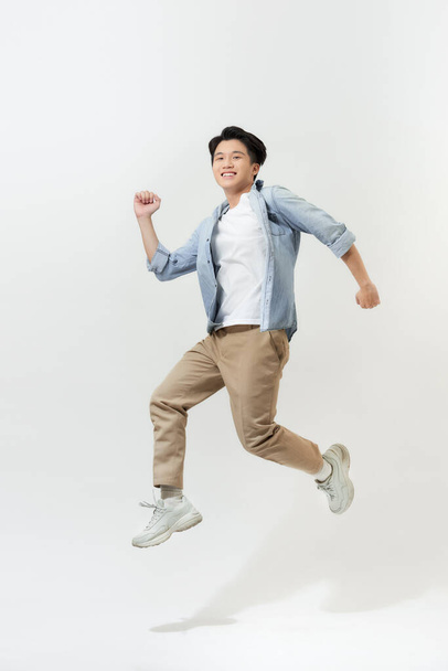 Estudante asiático pulando com mochila isolada no branco
 - Foto, Imagem