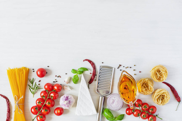 料理のためのイタリアのパスタ成分。白い木の背景に生パスタ、チーズ、野菜、スパイス、ハーブトップビュー。イタリアの健康的なビーガンフード. - 写真・画像