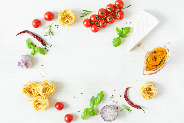 Keret olasz tészta összetevők főzés. Nyers tészta, sajt, zöldségek, fűszerek és fűszerek felső nézet fehér fa háttér. Olasz egészséges vegán ételek. - Fotó, kép