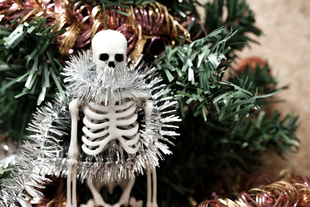 emberi csontváz a karácsonyfa díszek hátterében. az ünnep és az összes szilveszteri rendezvény lemondása - Fotó, kép