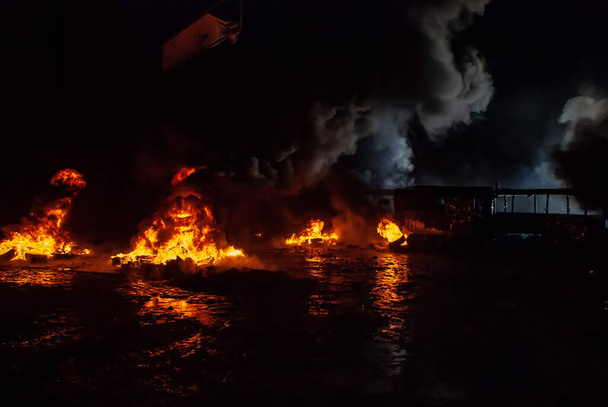 Disturbios, neumáticos quemados, hogueras en la noche
 - Foto, Imagen