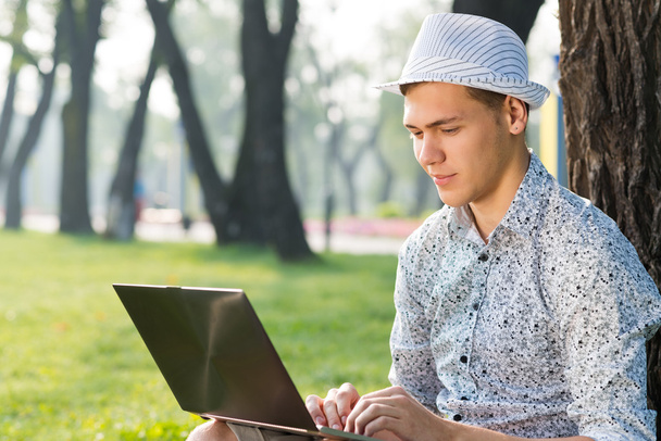 Young man working in the park with a laptop - Foto, Bild