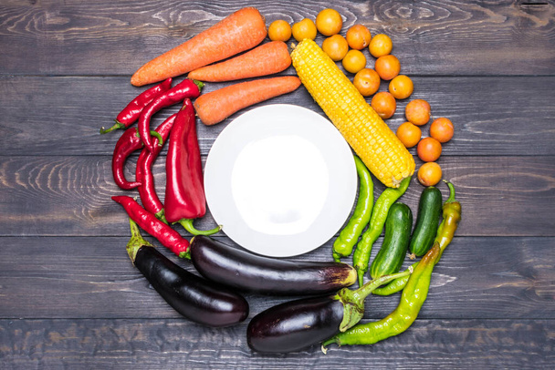 色別の新鮮な果物や野菜のテーブルトップの配置-コショウ、トマト、トウモロコシ、ニンジン、緑のサラダ、コリアンダー、ナス、キュウリ、バジル、ディル、タマネギ。健康食品のコンセプト. - 写真・画像