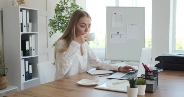 Businesswoman drinking coffee and working at office - Materiaali, video