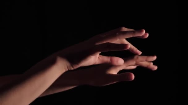 Close-up van vrouwelijke handen die chaotisch bewegen op een zwarte geïsoleerde achtergrond. Voet 3840x2160 (4K) opname in real time met kunstmatige professionele verlichting - Video