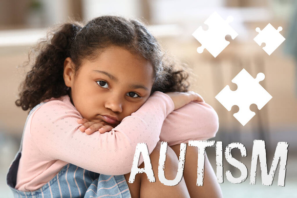 Маленька афро-американська дівчинка з аутистичним розладом сидить вдома. - Фото, зображення