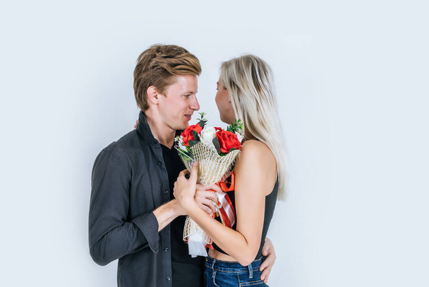 Mutlu genç çiftin portresi stüdyoda çiçeklerle birlikte aşk yaşıyor. - Fotoğraf, Görsel