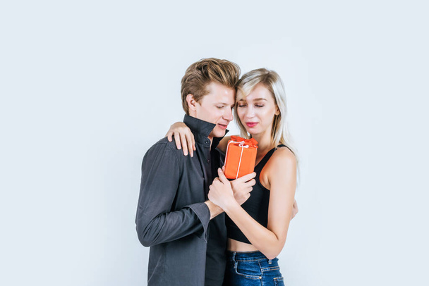 Портрет щасливої молодої пари кохання разом сюрприз з подарунковою коробкою в студії
 - Фото, зображення