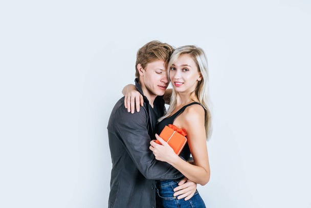 Portrait de heureux jeune couple amour ensemble surprise avec boîte cadeau en studio - Photo, image