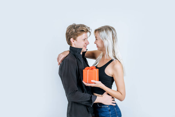 幸せな若いカップルの愛の肖像画一緒に驚きでギフトボックスでスタジオ - 写真・画像