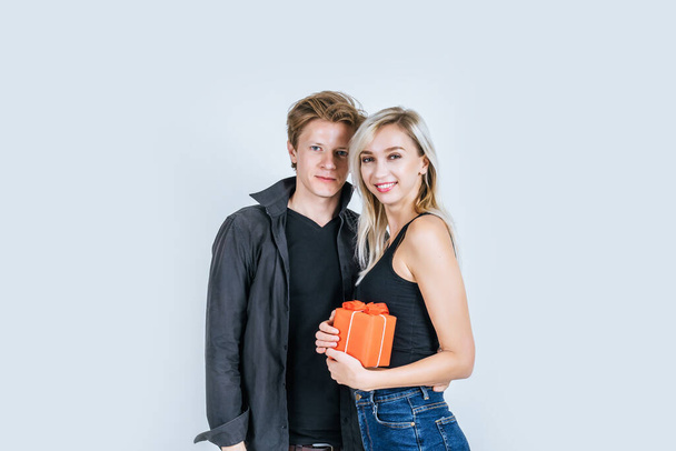 Retrato de feliz pareja joven amor juntos sorpresa con caja de regalo en el estudio
 - Foto, imagen