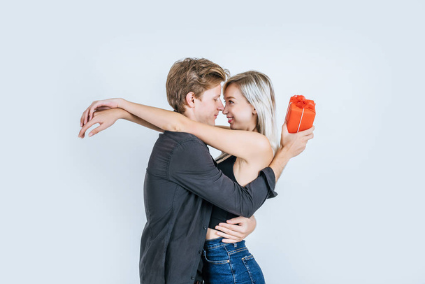 Портрет счастливой молодой пары любовь вместе сюрприз с подарочной коробкой в студии
 - Фото, изображение