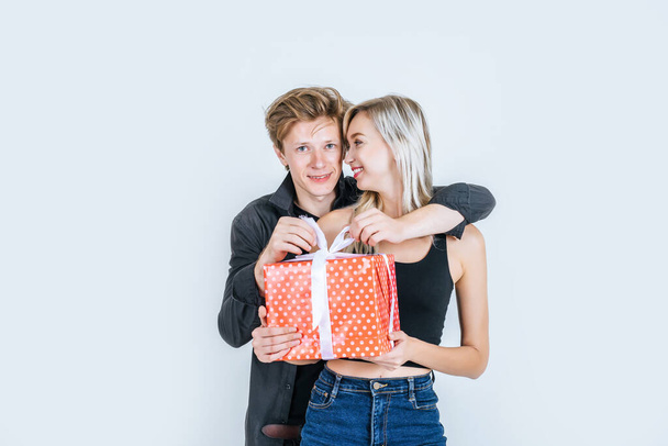 Retrato de feliz pareja joven amor juntos sorpresa con caja de regalo en el estudio
 - Foto, imagen