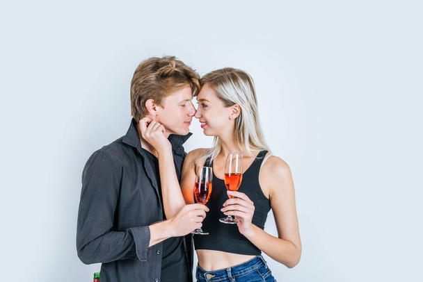 Retrato de pareja joven y feliz bebiendo vino en el estudio
 - Foto, Imagen