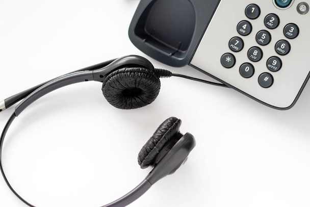 Bedrade headset op een drukknop telefoon. werktijden van een medewerker van een callcenter - Foto, afbeelding