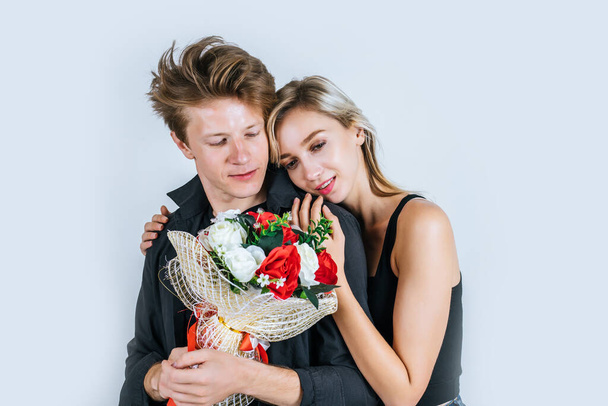 Portrait of happy young couple love together with flower in studio - Photo, Image