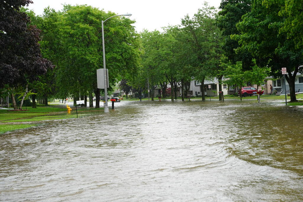 Громадяни Фонд-дю-Лак їдуть затопленими вулицями через свої транспортні засоби від великої зливи в другій половині дня в юності 2020 року..   - Фото, зображення