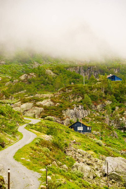 Norwegian country house cabin in mountains. Foggy misty landscape in Norway, Scandinavia - Fotó, kép