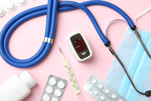 Flat lay composition with fingertip pulse oximeter and medical items on pink background - Fotografie, Obrázek