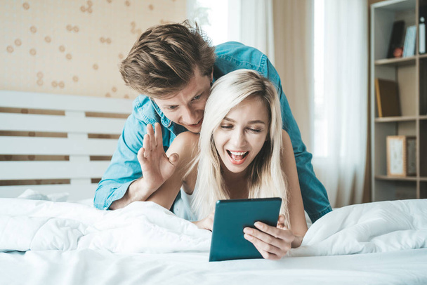Couple heureux Utilisation de tablette sur le lit - Photo, image