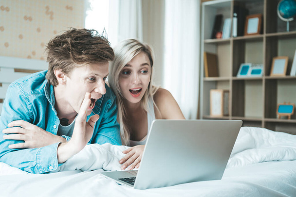 Ευτυχισμένο ζευγάρι Χρησιμοποιώντας φορητό υπολογιστή στο κρεβάτι - Φωτογραφία, εικόνα