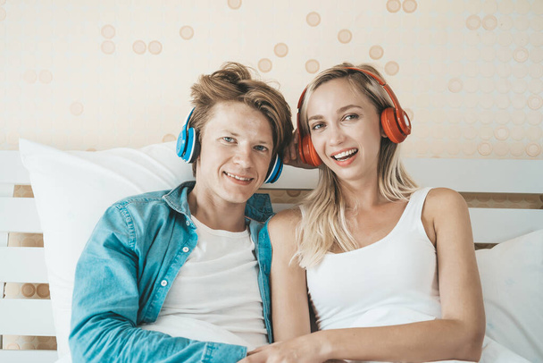 Happy couple listening song in the morning at bedroom - Фото, изображение