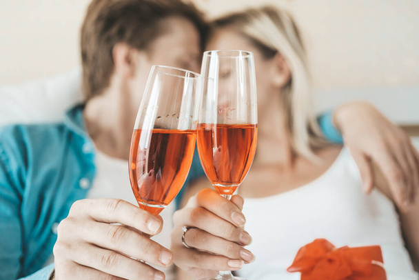Happy Couple drinking wine in the bedroom - Foto, imagen