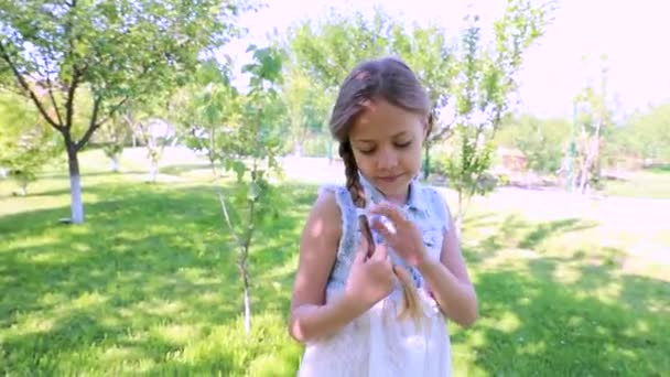 beautiful girl in a summer garden, children's holidays. little cute girl in a green garden. child's portrait - Πλάνα, βίντεο