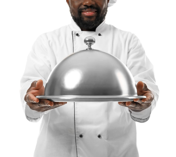 Man Afro-Amerikaanse chef-kok met dienblad en cloche op witte achtergrond - Foto, afbeelding