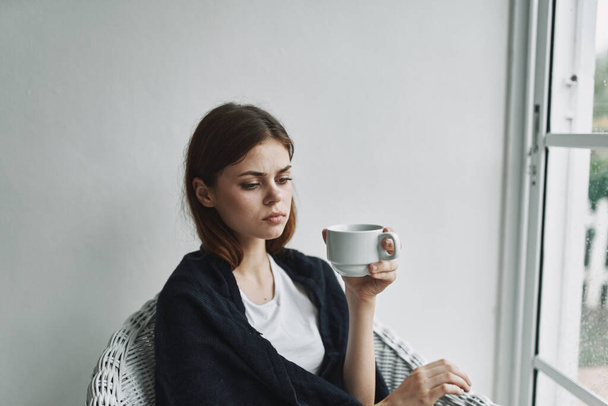 Triste femme dans une chaise avec une tasse de café  - Photo, image