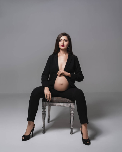 Studio fashion portrait pregnant happy woman. Pregnant young mother portrait, caressing her belly and smiling close-up. Healthy Pregnancy concept. - Fotó, kép