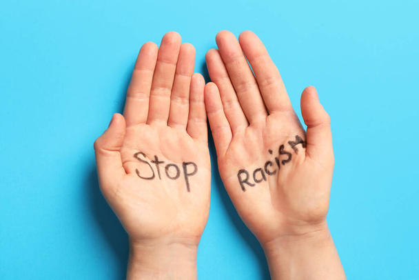 Mani femminili con testo scritto STOP RACISM su sfondo a colori - Foto, immagini