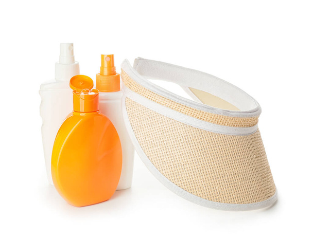 Bottiglie di crema solare con cappello su sfondo bianco - Foto, immagini