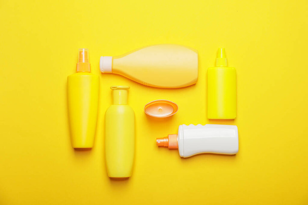 Bottles of sunscreen on color background - Fotoğraf, Görsel