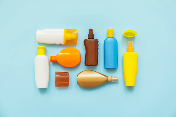 Bottles of sunscreen on color background - Foto, imagen