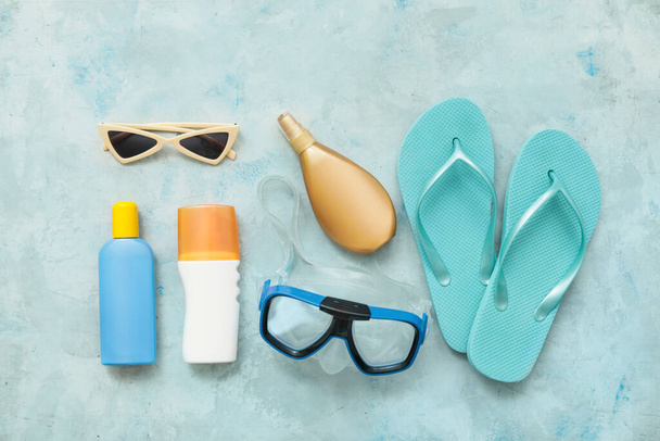 Strand accessoires met zonnebrandcrème op kleur achtergrond - Foto, afbeelding