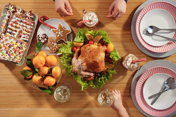 perhe syö kanaa istuen juhla-illallisella jouluaattona - Valokuva, kuva