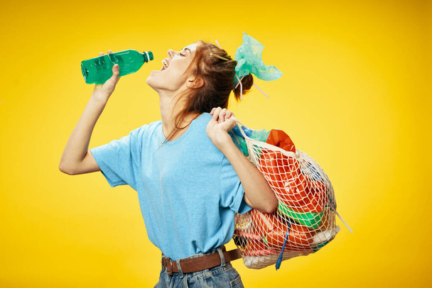 Woman with a bottle of water and plastic objects  - Фото, зображення