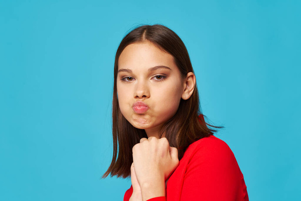 Emotional girl in a red shirt pouted lips and looks  - Foto, imagen