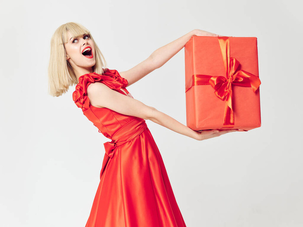 Bella donna in un vestito rosso con una scatola regalo  - Foto, immagini